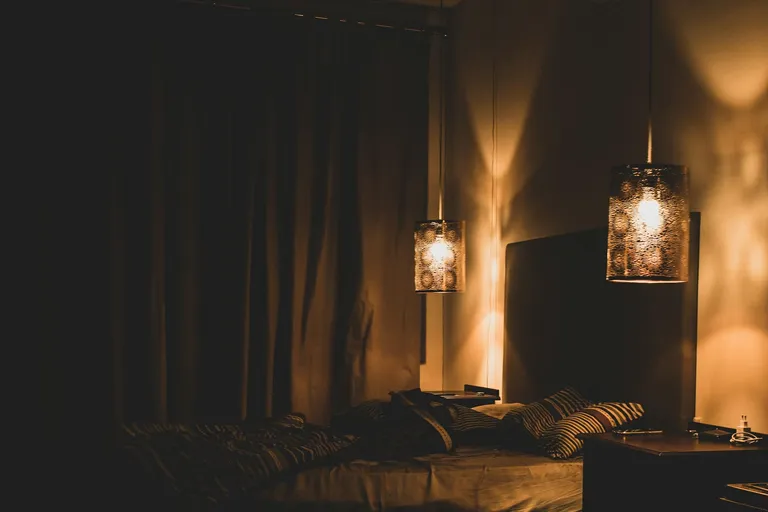 Gedämpft beleuchtetes Schlafzimmer mit warmen Wandleuchten