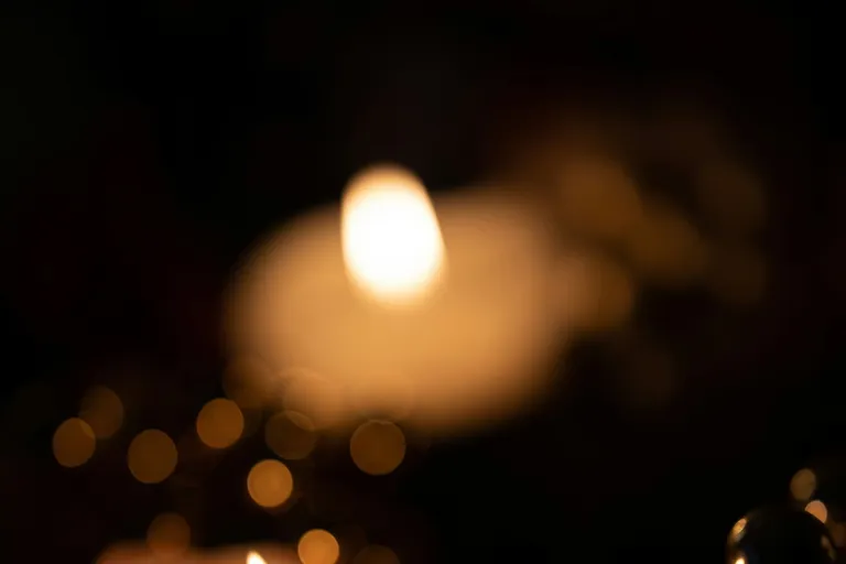 Brennende Kerze mit warmem Licht im Dunkeln
